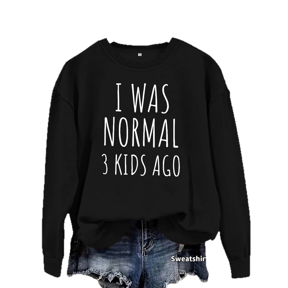 Black crewneck sweatshirt with white text "I WAS NORMAL 3 KIDS AGO" tucked into denim shorts.
