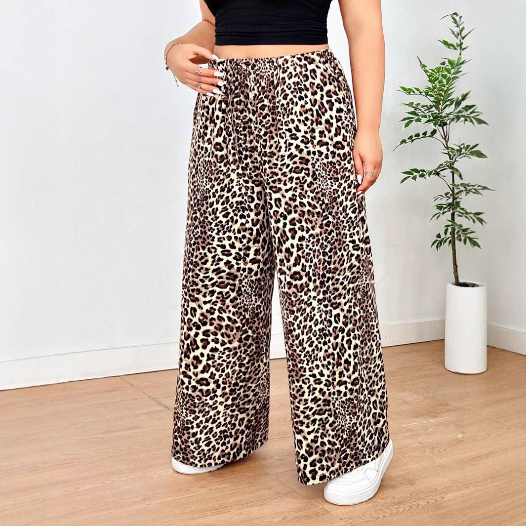 Leopard print wide-leg pants in brown and black with an elastic waistband, worn with white sneakers.