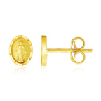 14k yellow gold oval religious medallion post earrings with detailed design on a white background.