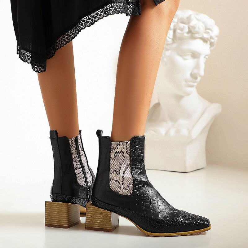 Black faux leather chelsea boots with a snakeskin side panel, square block heel, and croc-embossed texture.
