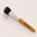 Natural bamboo brush from Timeless Organics Skin Care with smooth wooden handle and soft bristles for gentle cleansing.