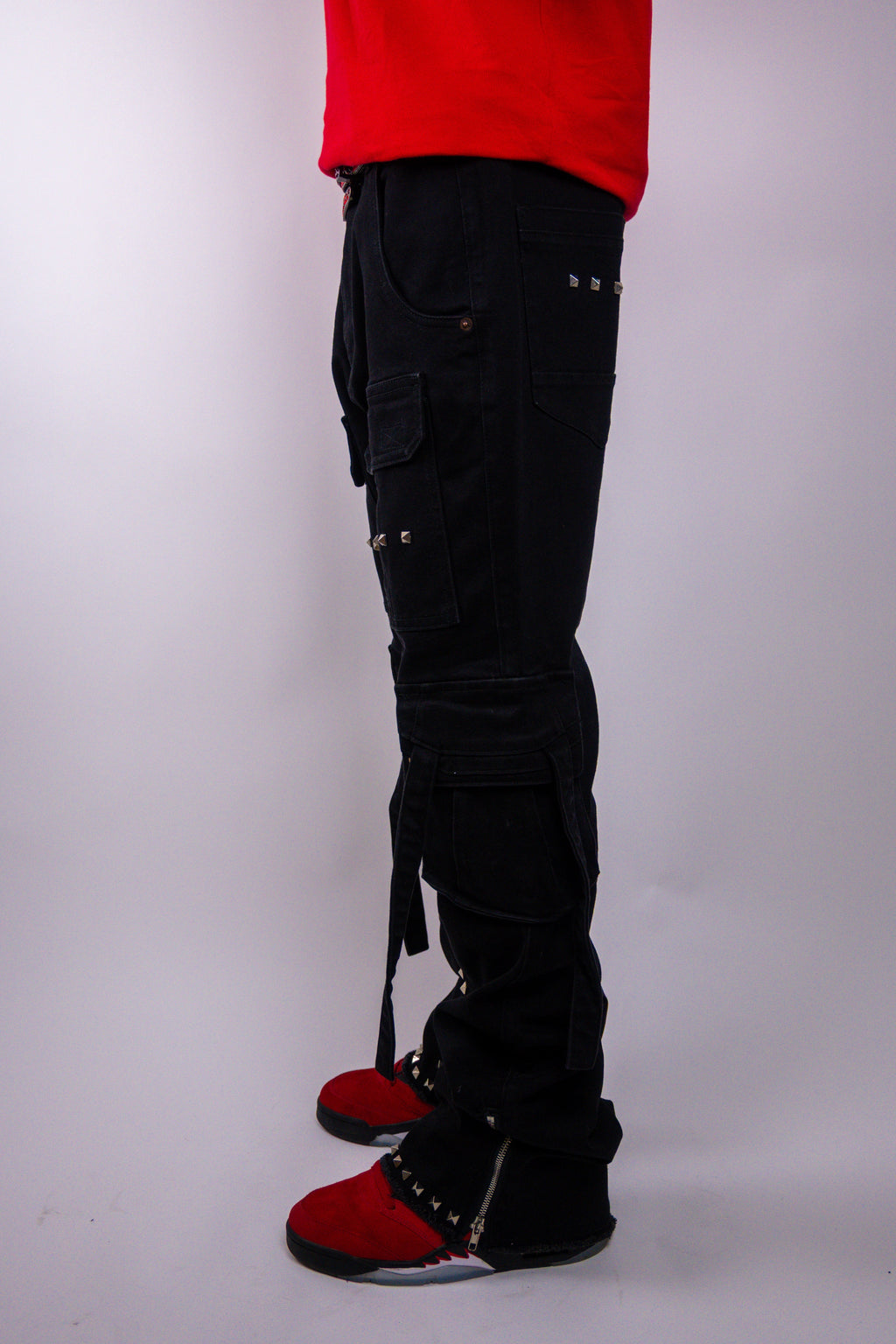 ARMOR JEANS studded stacked cargo jeans with multiple pockets and distressed details, shown on a hanger.
