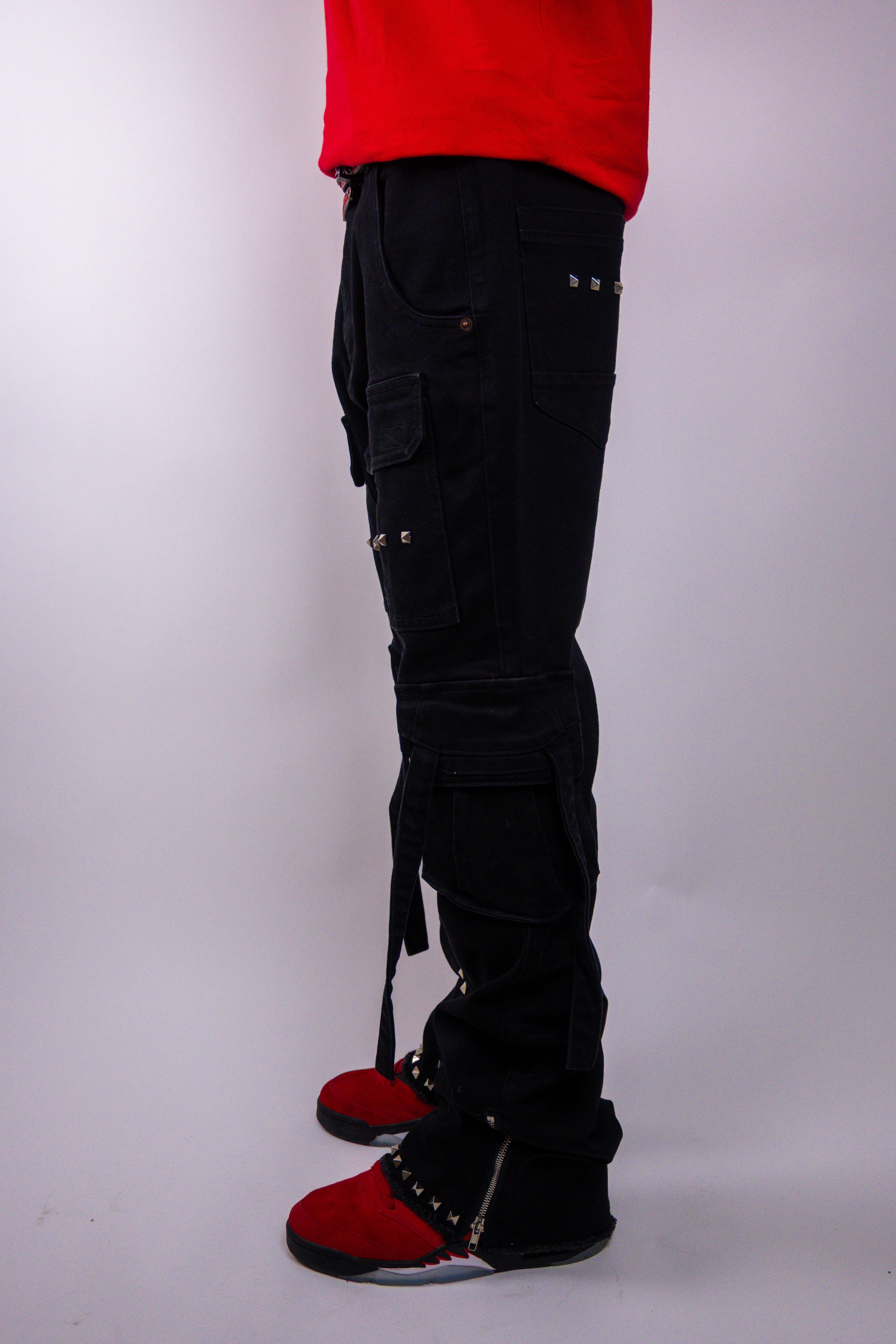 ARMOR JEANS studded stacked cargo jeans with multiple pockets and distressed details, shown on a hanger.