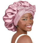 Double-layer satin ribbon hair bonnet with bow, plush fabric sleep cap designed for hair protection and gentle sleep care.