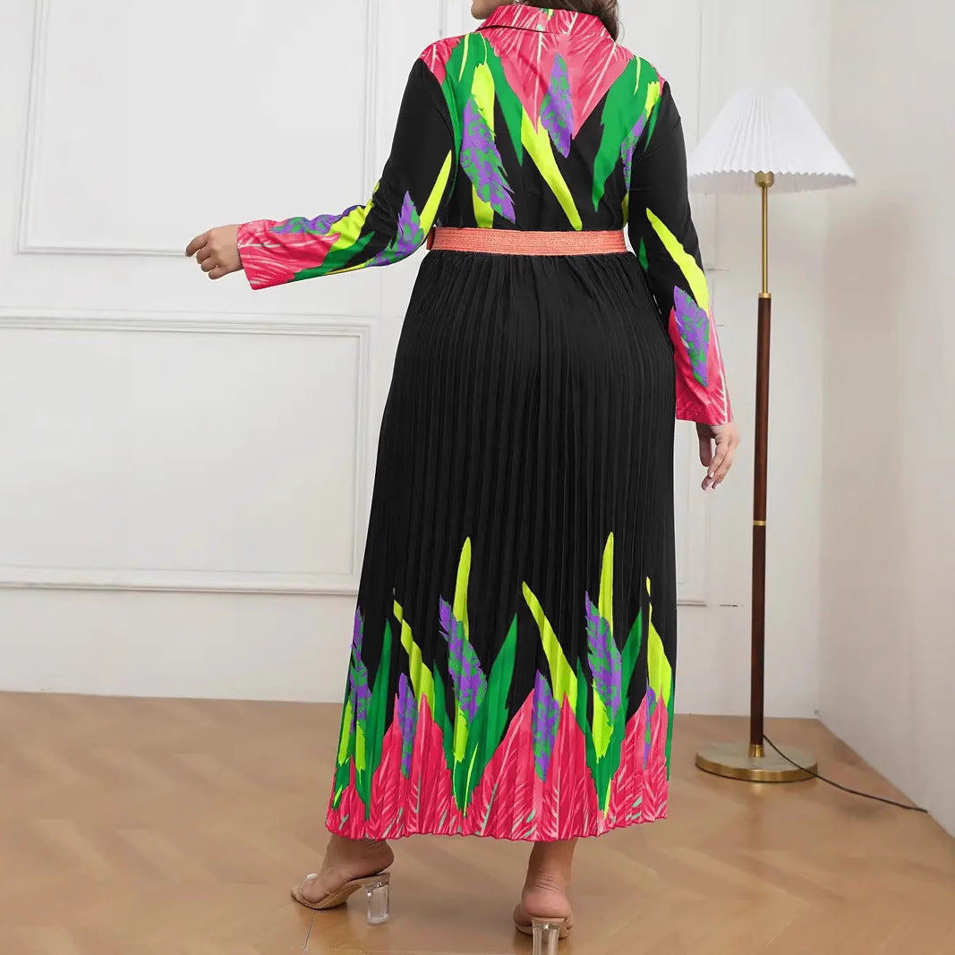 Back view of a black pleated maxi dress with bright pink, green, and purple tropical leaf patterns and a matching waist belt.