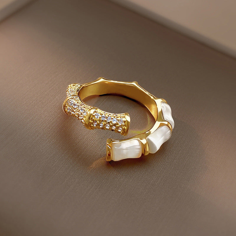 Gold bamboo-style ring, half pavé cubic zirconia, half white enamel inlays, open-band design.