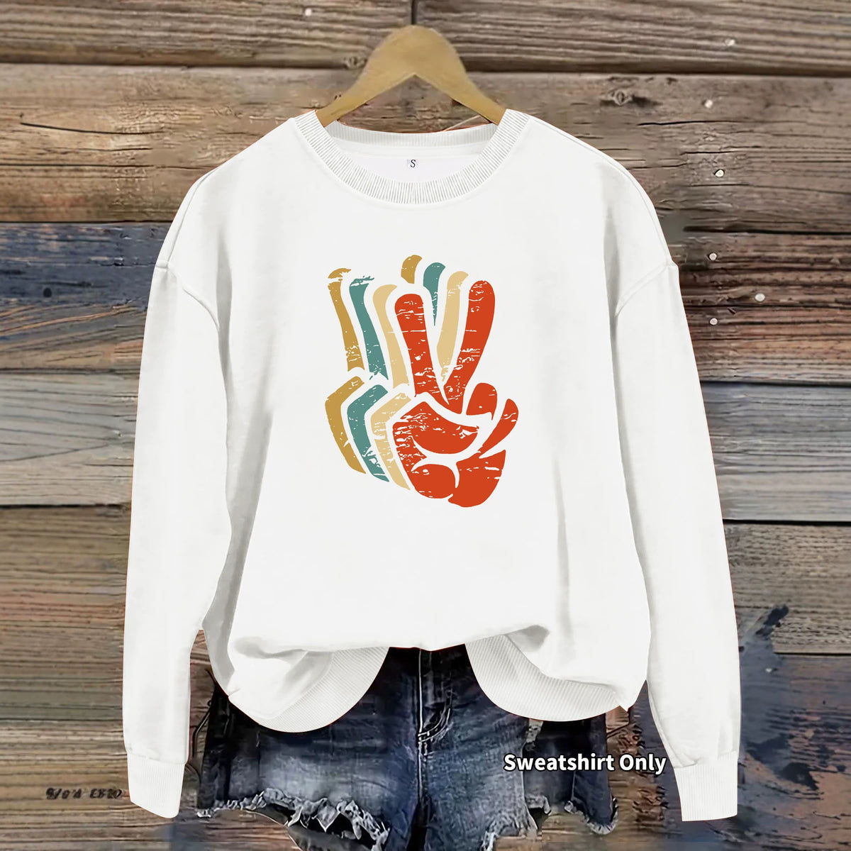 White cotton blend sweatshirt, crew neck, long sleeves, distressed multicolored retro peace sign graphic.