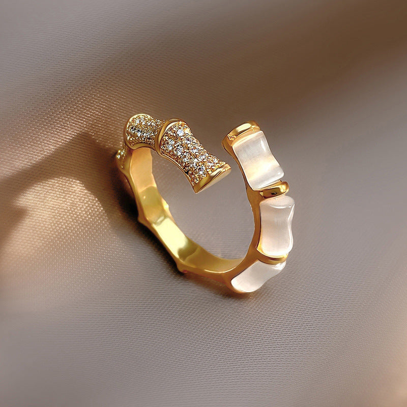 Gold bamboo-style open ring with sparkling crystal pavé and white opalescent insets.
