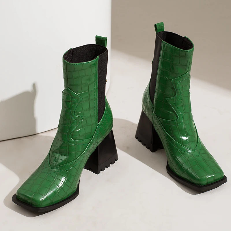 Green crocodile-embossed faux leather ankle boots with square toes and black lug block heels.