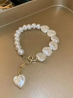 Elegant heart-shaped pearl beaded bracelet with stainless steel clasp from Plush Fashion Hub, showcasing delicate jewelry design.