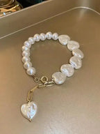 Elegant heart-shaped pearl beaded bracelet with stainless steel clasp from Plush Fashion Hub, showcasing a delicate and stylish accessory.