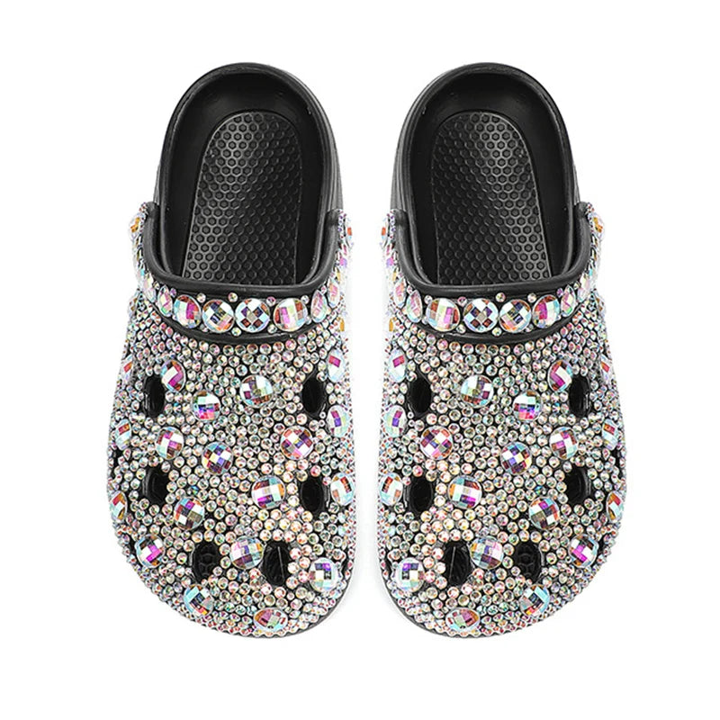Black slip-on clogs fully encrusted with iridescent, multicolored rhinestones and larger crystal accents.