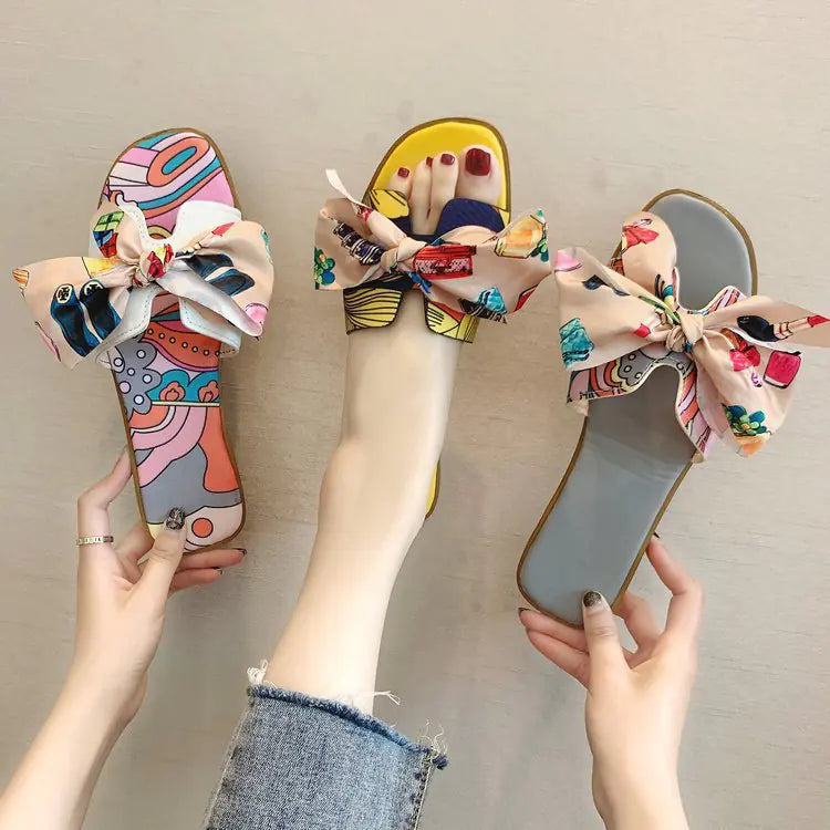 Women’s summer flat slippers with bow detail from Plush Fashion Hub, featuring comfortable slip-on sandal design.