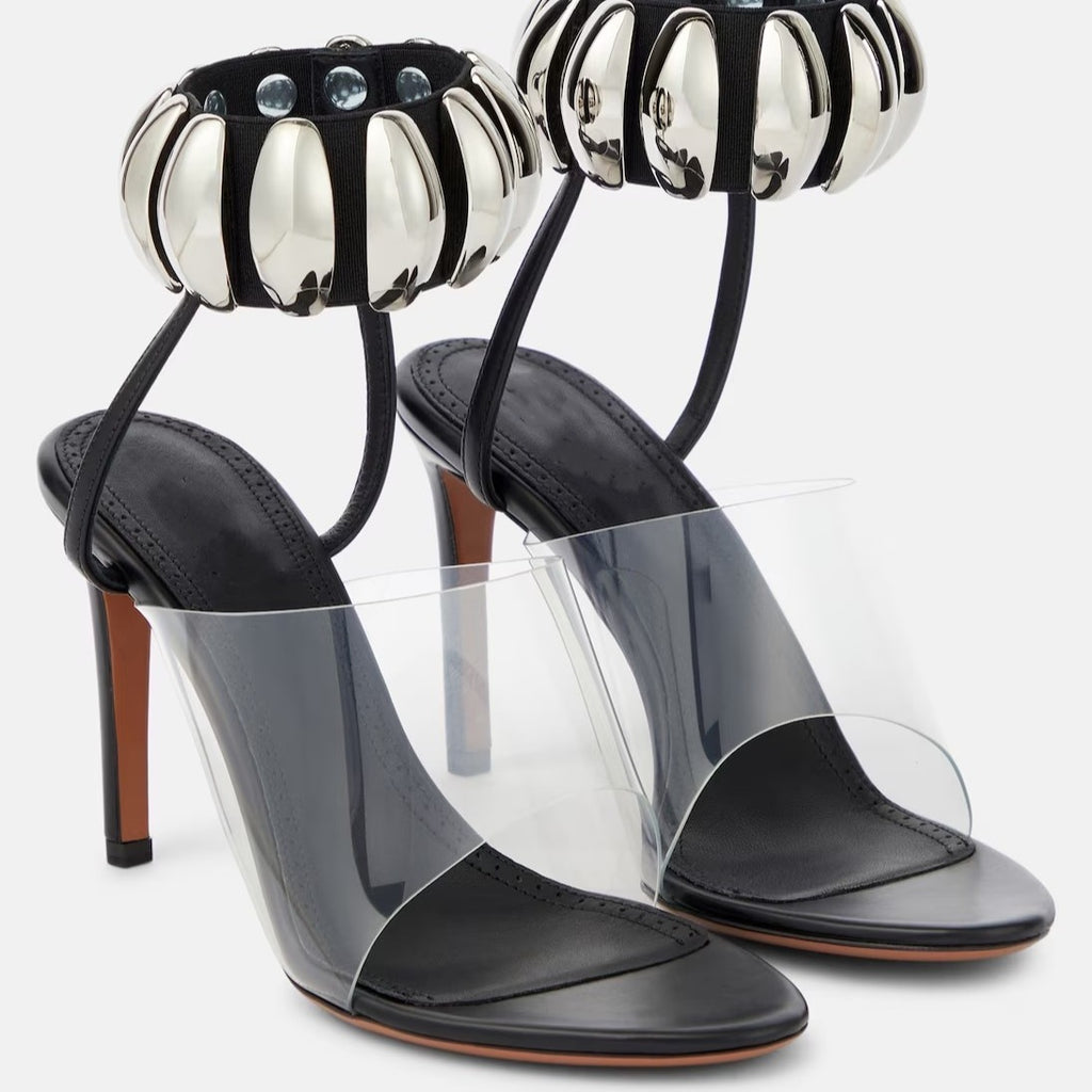 Clear PVC open-toe stilettos with black leather insoles and silver metallic beaded ankle straps.