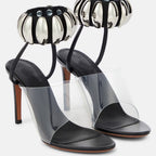 Clear PVC open-toe stilettos with black leather insoles and silver metallic beaded ankle straps.