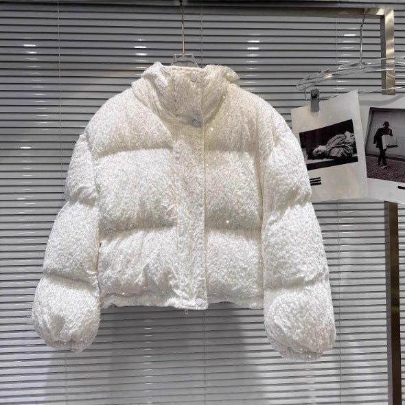 White sequin puffer jacket with high neck, hanging on hanger.