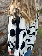 Plus size women's abstract print long sleeve button-up shirt by Plush Fashion Hub, featuring a stretch fit and vibrant design.