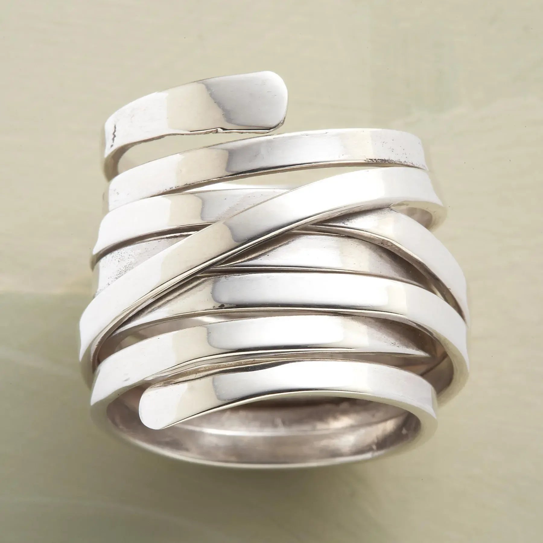 Silver-tone geometric winding hoop ring with modern design, crafted by Plush Fashion Hub, displayed on a neutral background.