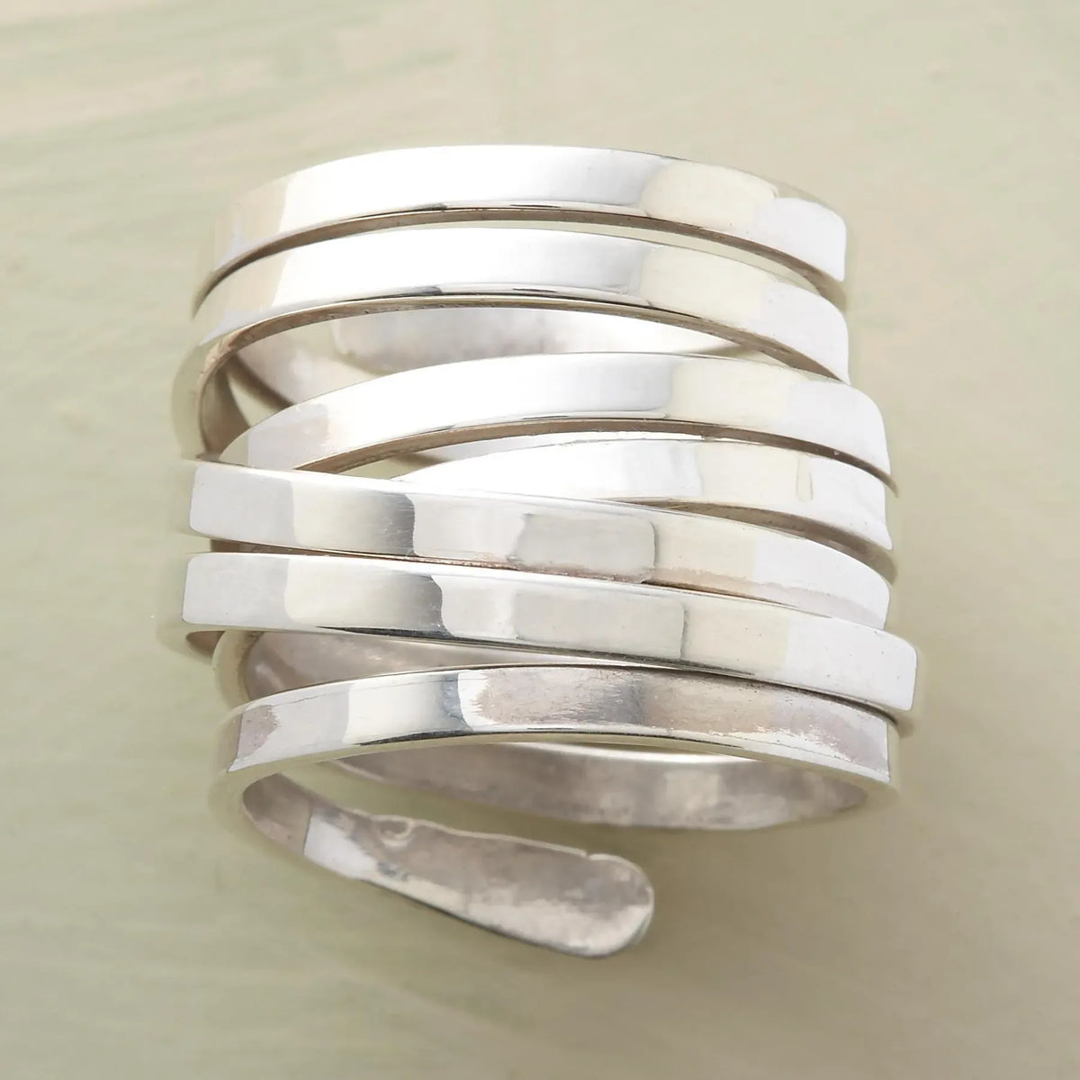 Silver-tone geometric winding hoop ring by Plush Fashion Hub, featuring modern metal jewelry design with intricate winding details.
