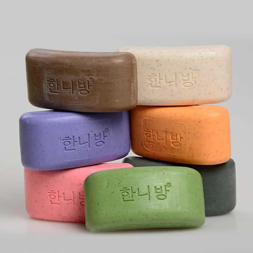 A stack of seven colorful rectangular soaps with speckles and embossed Korean text on the front.