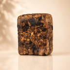 Raw African Black Soap by Timeless Organics Skin Care, showing a bar of natural black soap with textured surface and earthy tones.