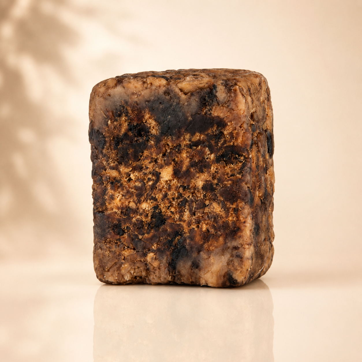 Raw African Black Soap by Plush Fashion Hub, showing a natural, textured soap bar in a minimalist setting.