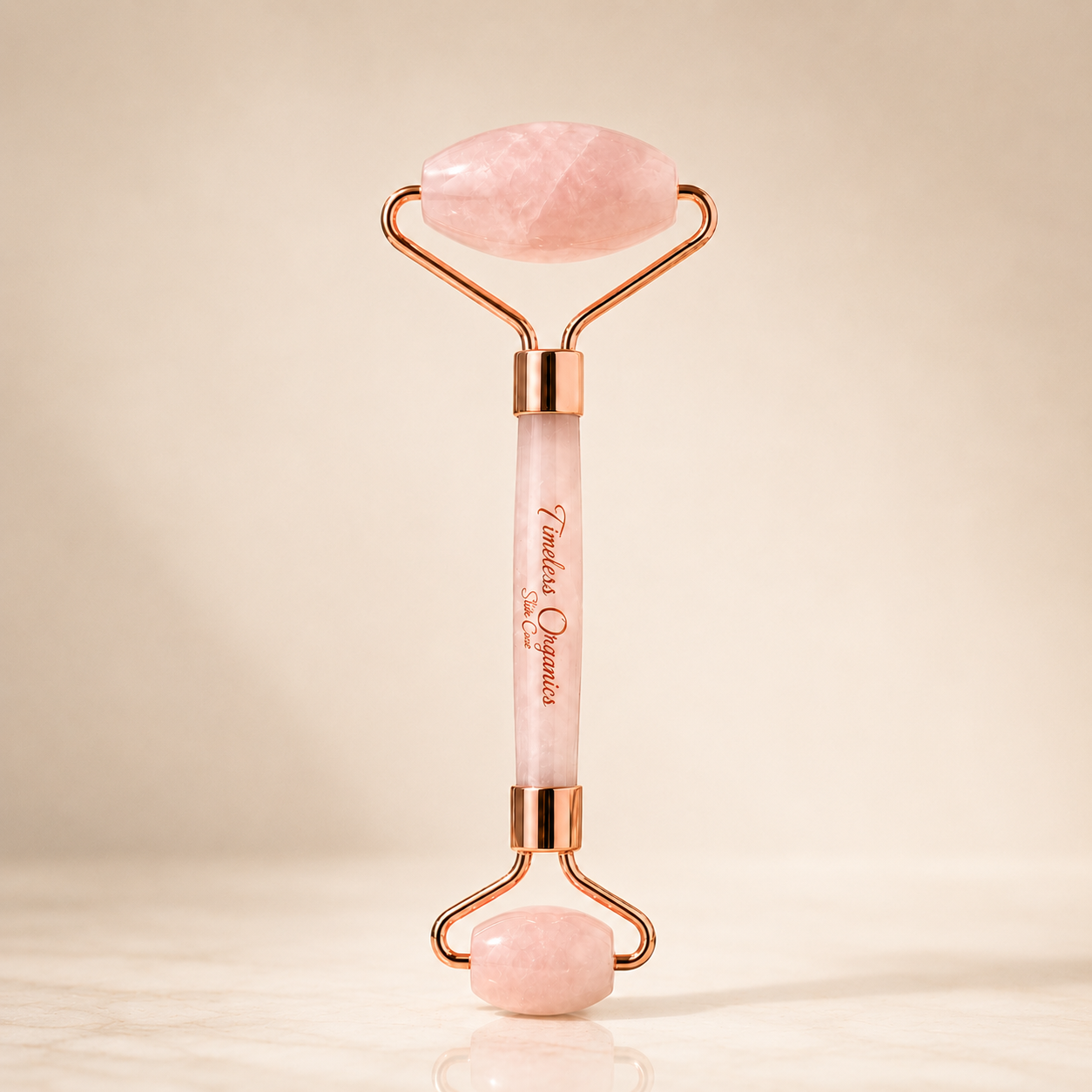 Rose quartz facial roller device with dual roller heads for skincare, by Plush Fashion Hub, shown on a clean surface.