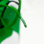 Elastic shoelace in Lucky Green by Bread, shown threaded through sneakers with a vibrant green color and flexible design.