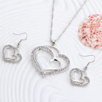 Double heart earrings and necklace wedding set featuring silver-tone jewelry with elegant heart-shaped designs.