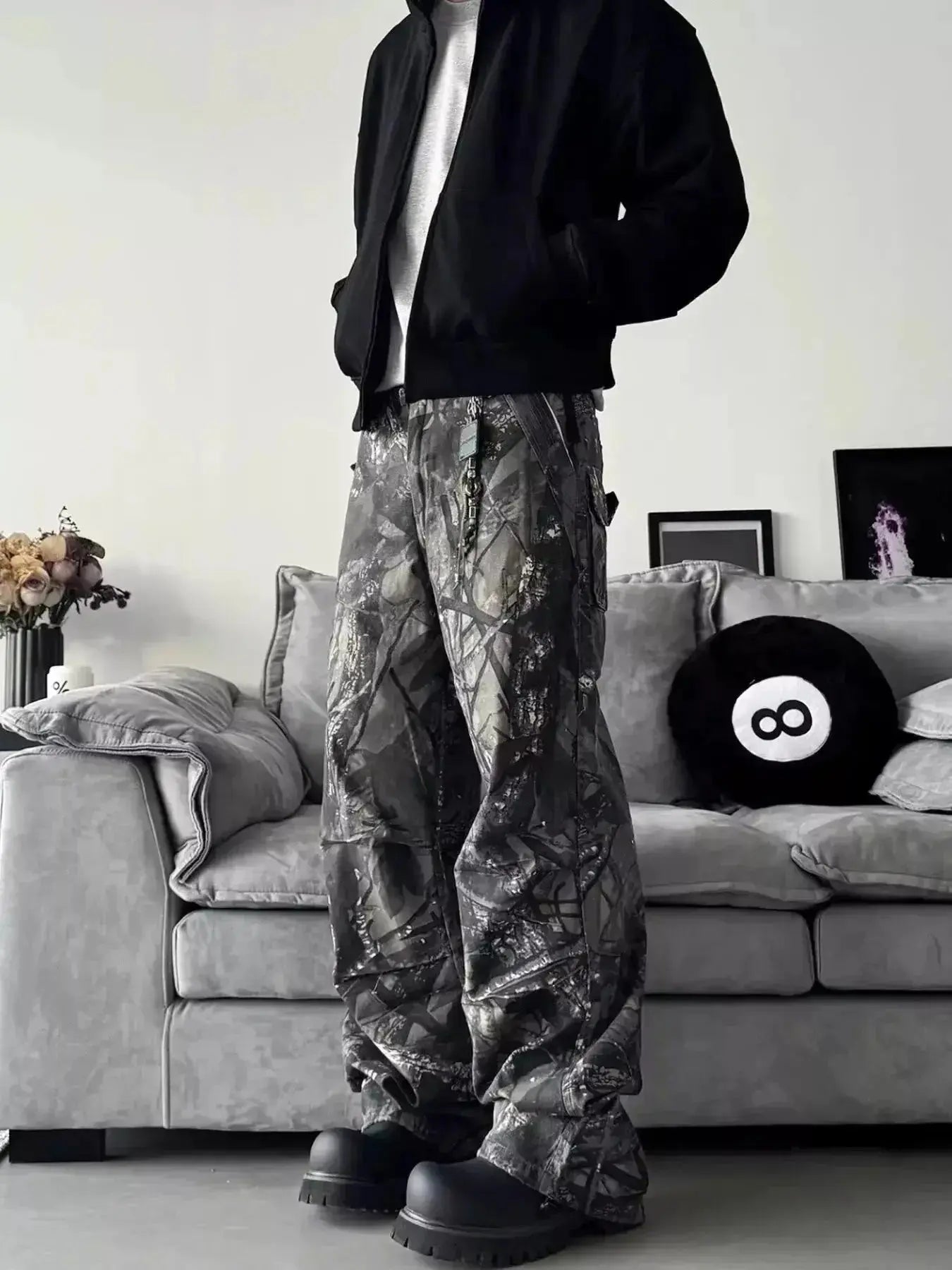 Men's relaxed fit camouflage print jeans showing urban casual streetwear style, denim fabric, and trendy camo pattern.