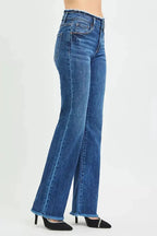 Plush Fashion Hub mid-rise bootcut jeans with frayed waist and raw hem detail, showcasing a stylish denim look.