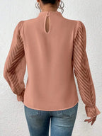 Elegant plush fabric mock neck blouse with flounce sleeves from Plush Fashion Hub, shown on a model.