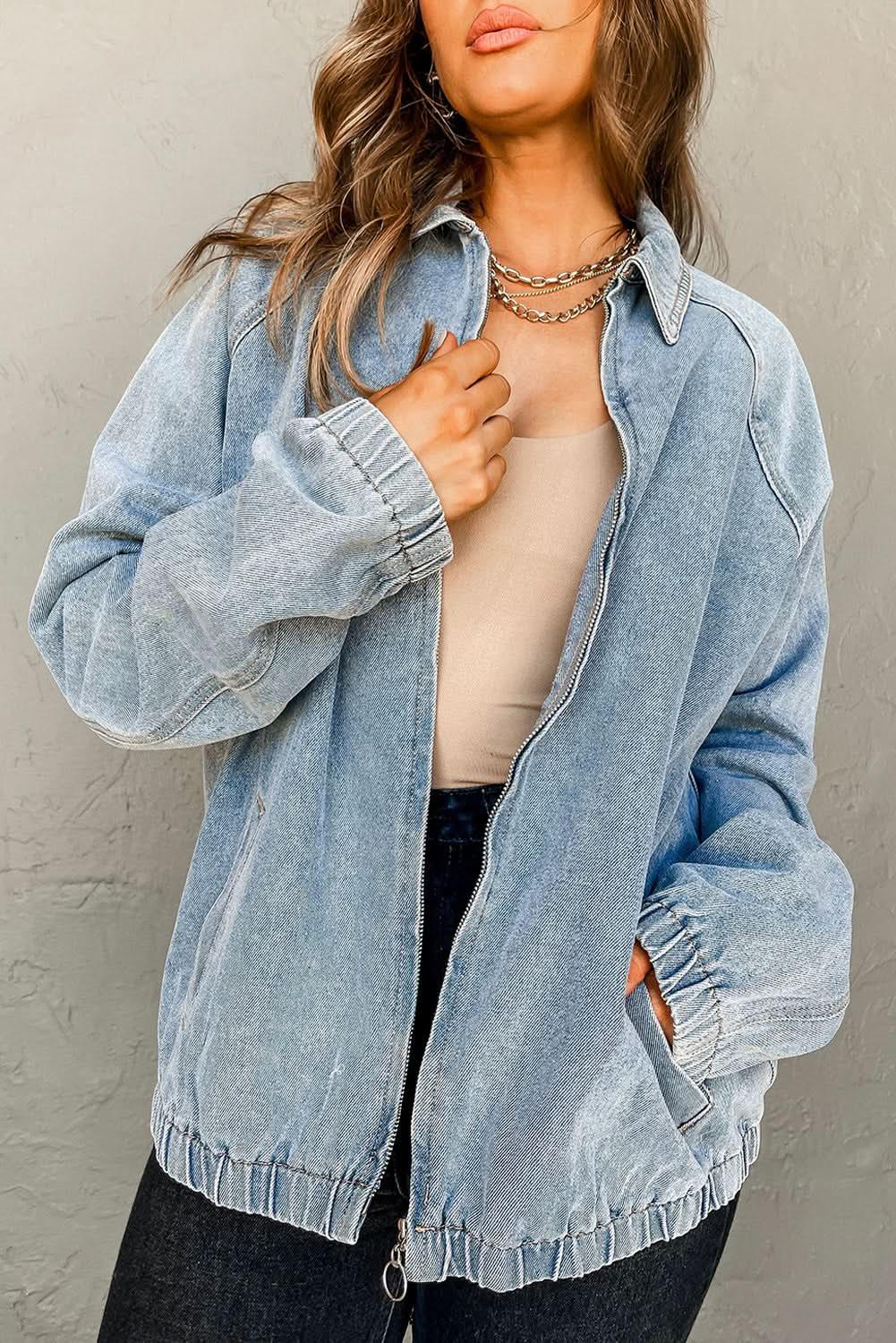 Blue denim jacket with zip-up front, raglan sleeves, and elastic hem from Gilded Glamour Shop, showcasing casual outerwear style.