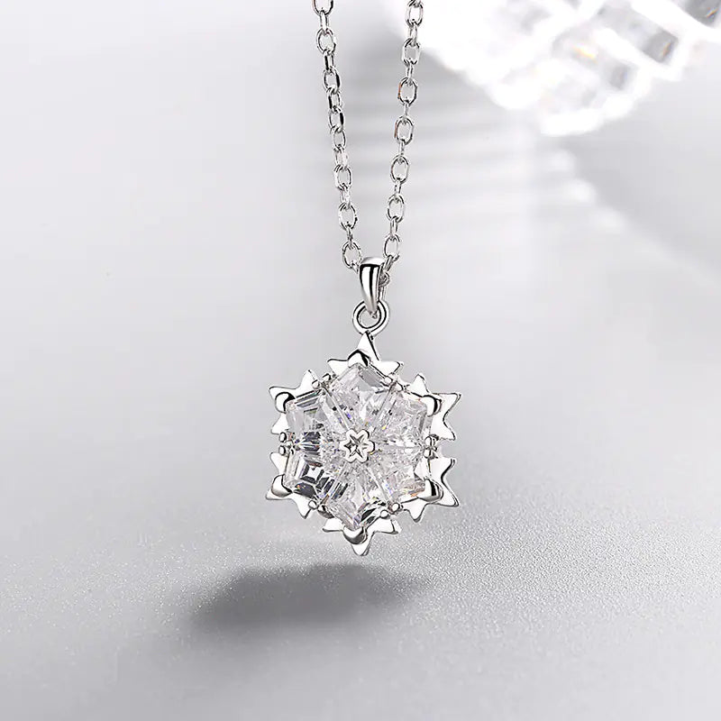 Silver snowflake necklace with diamond pendant, elegant jewelry piece featuring a sparkling snowflake design and intricate detailing.