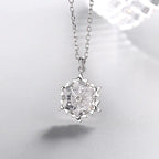 Silver snowflake necklace with diamond pendant, elegant jewelry piece featuring a sparkling snowflake design and intricate detailing.