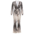 Deep V plunge off-shoulder top paired with high waist bootcut pants jumpsuit by Plush Fashion Hub, stylish and elegant for fashion-forward looks.