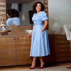 Women’s high waist dress with puff sleeves and round neck by Plush Fashion Shop, shown on a model in a stylish pose.