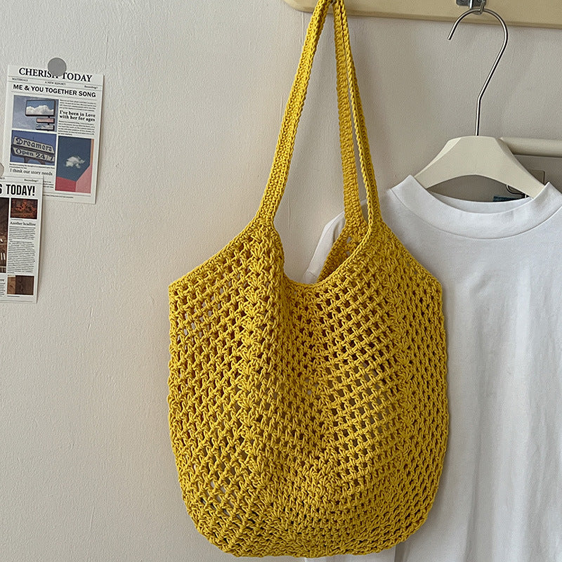 Large capacity cotton woven bag by Wanita Store, with hollow cutouts and straw design, perfect for beach and vacation outings.