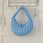 Handmade crocheted beige portable straw beach bag with hand carry straps, perfect for seaside vacations by Bella Mia.