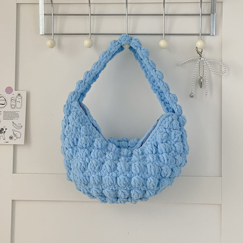 Handmade crocheted beige portable straw beach bag with hand carry straps, perfect for seaside vacations by Bella Mia.