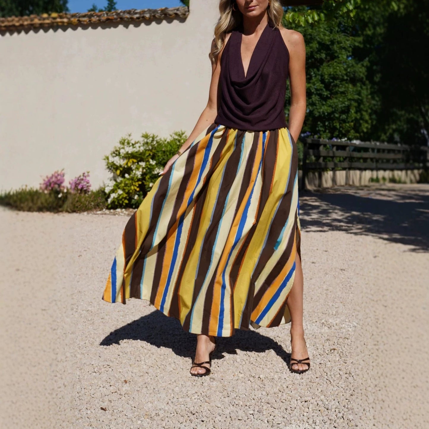 Elegant women's skirt with colorful striped pattern, slit hemline, and a flowing design from Plush Fashion Hub.