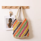 Colorful striped woven straw shoulder bag with cutout design, perfect for beach or casual vacation outings.
