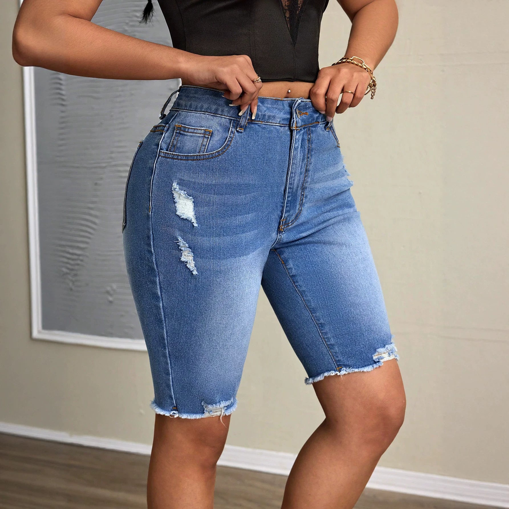Women’s casual denim tight shorts by Wanita Store, featuring a fitted design and classic blue wash, worn with a casual top.
