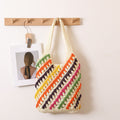 Colorful striped woven shoulder straw bag with cutout design, perfect for beach or casual summer vacations.