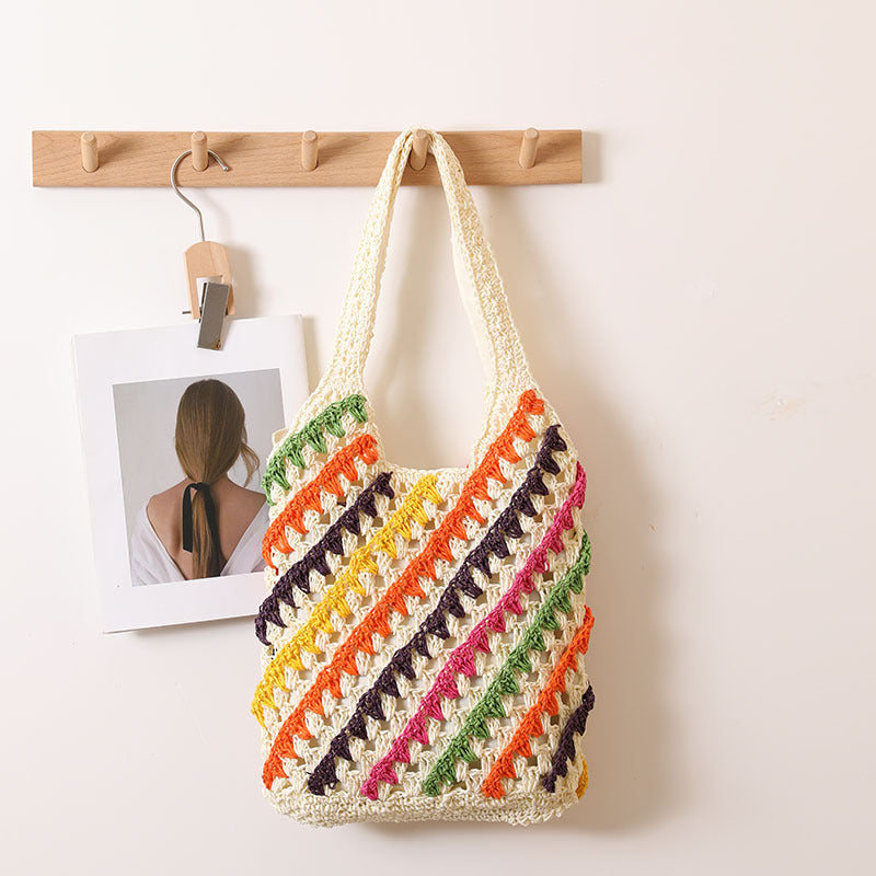 Colorful striped woven straw shoulder bag with cutout and hollow design, perfect for beach or casual vacation outings.