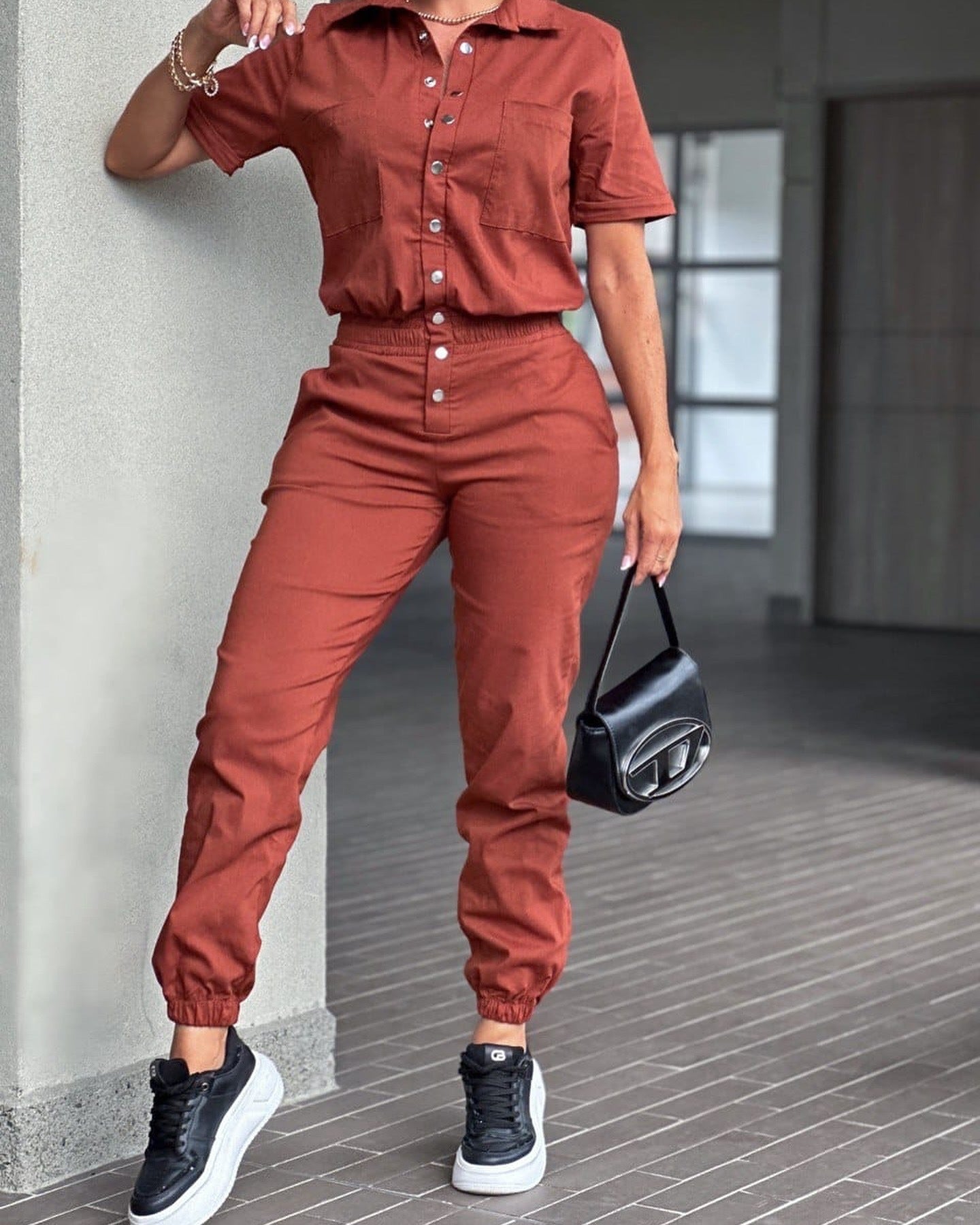 Casual women's ankle-tied jumpsuit by Wanita Store featuring a collared neckline, pocket, elastic waist, and button details.