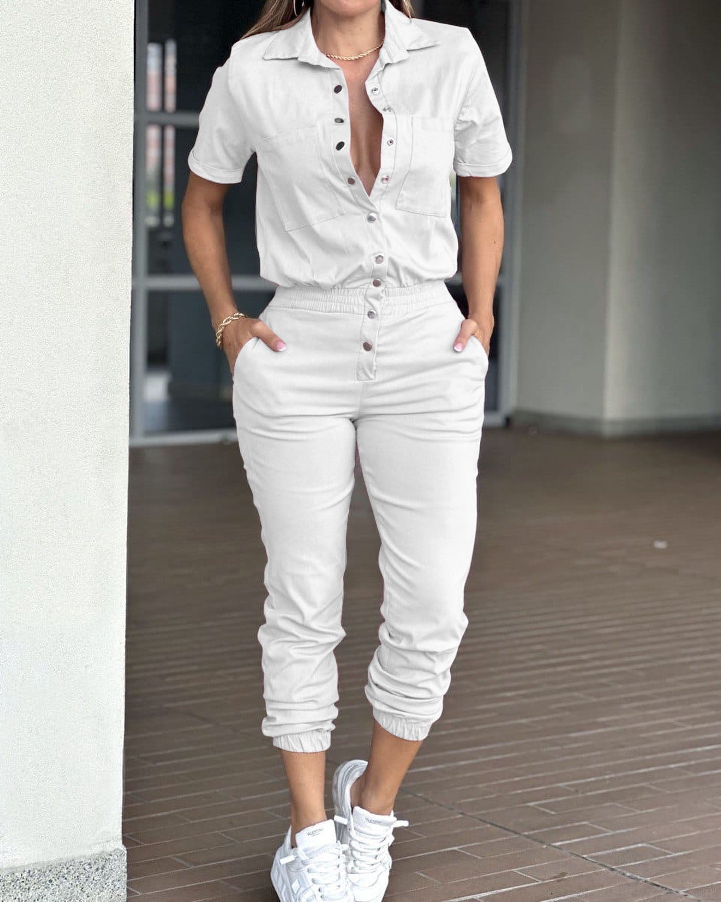 Casual women's ankle-tied jumpsuit with collar, pockets, elastic waist, and button details by Plush Fashion Hub.