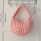 Handmade beige crochet straw beach bag with solid color design, featuring hand-carry handles, perfect for seaside vacations.