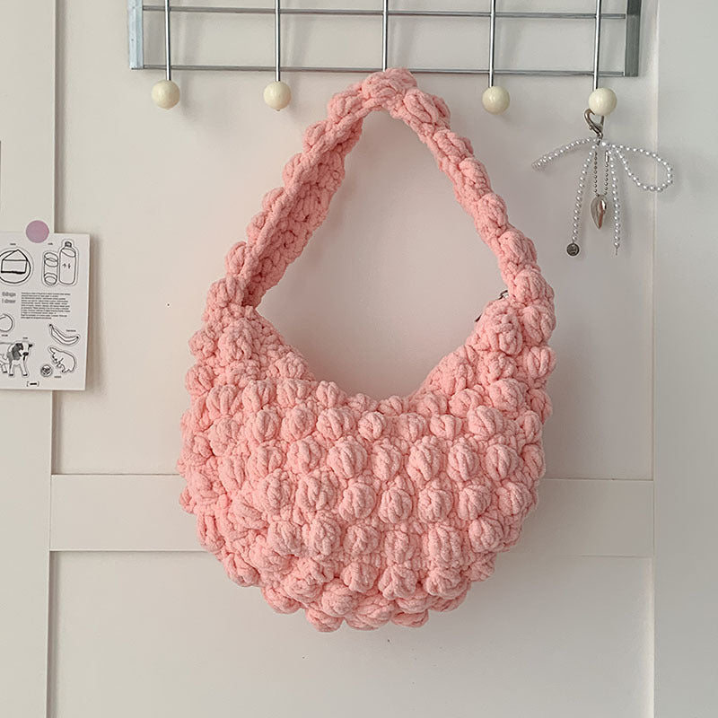 Handmade beige crochet straw beach bag with solid color design, featuring hand-carry handles, perfect for seaside vacations.