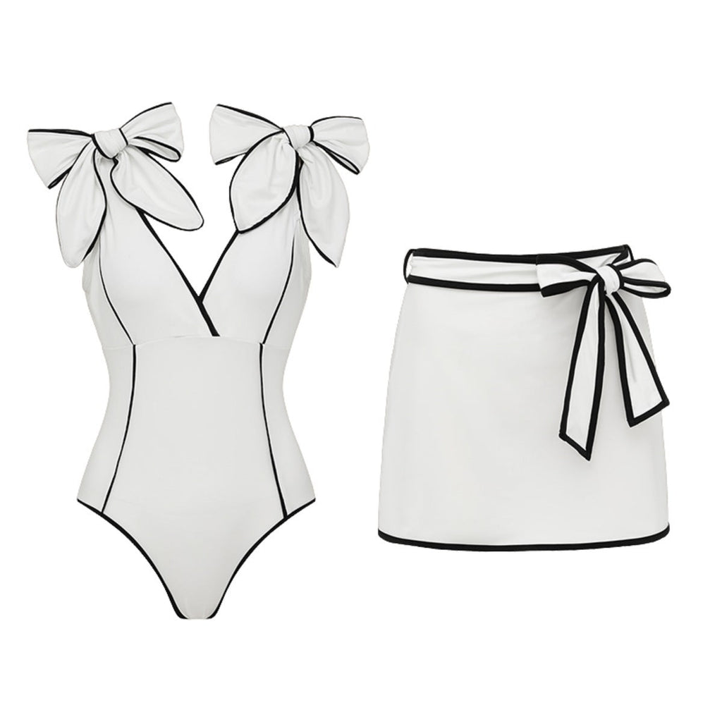 Black and white matching girl’s swimsuit with bow and white skirt, stylish swimwear for women by Plush Fashion Hub.